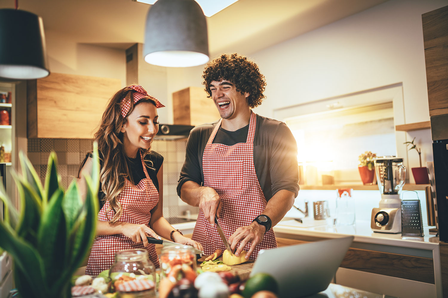 Couple souriant en train de cuisiner