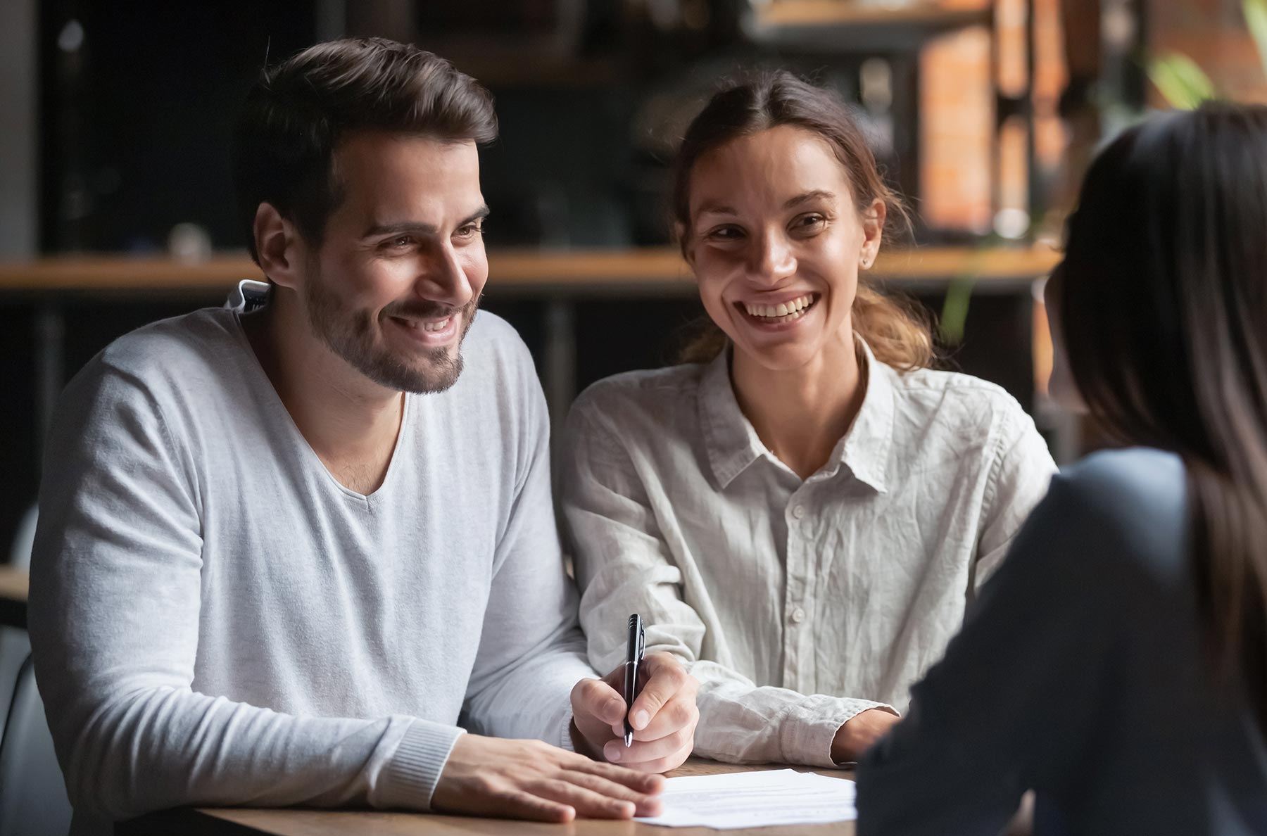 Couple souriant en train de signer un document